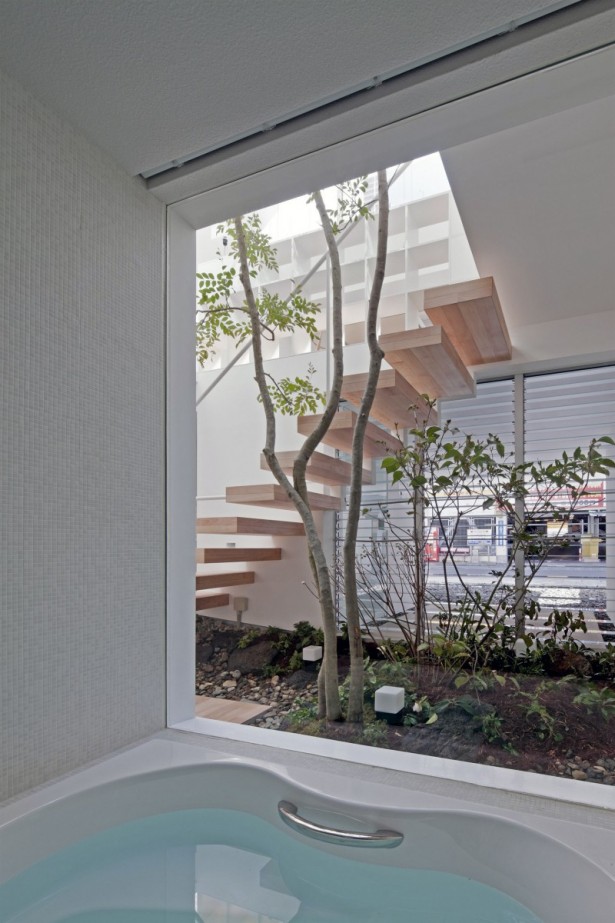 large-glasses-white-bathtub-indoor-garden-tree-wooden-staircase-615x923